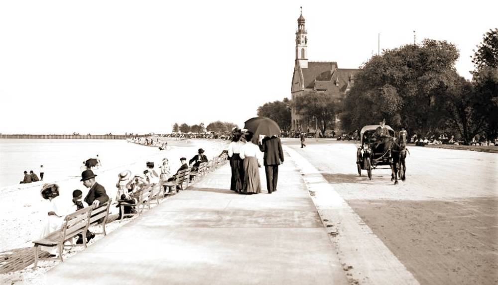 PHOTO - CHICAGO - JACKSON PARK BEACH - PEOPLE ON BENCHES AND WALKING - GERMAN BUILDING IN BACKGROUND - c1910