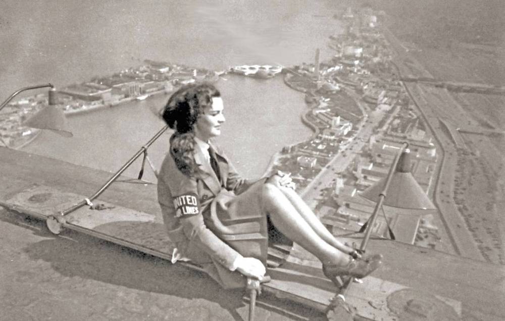PHOTO - CHICAGO - MODEL OR WOMAN ATHLETE POSING ON MACHINE HIGH OVER THE CENTURY OF PROGRESS WORLD'S FAIR GROUNDS - UNITED AIRLINES ARM BAND - c1933