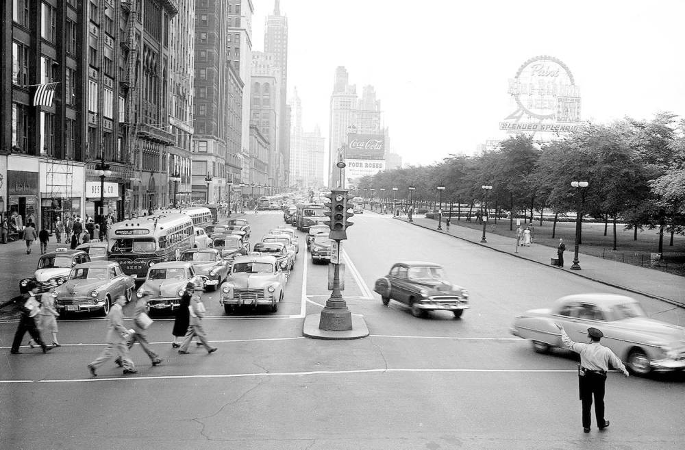 PHOTO - CHICAGO - MICHIGAN AVE AT MONROE - TRAFFIC BEING DIRECTED BY A POLICEMAN - NOTE BUSES ANDS SIGNS - EARLY 1950s