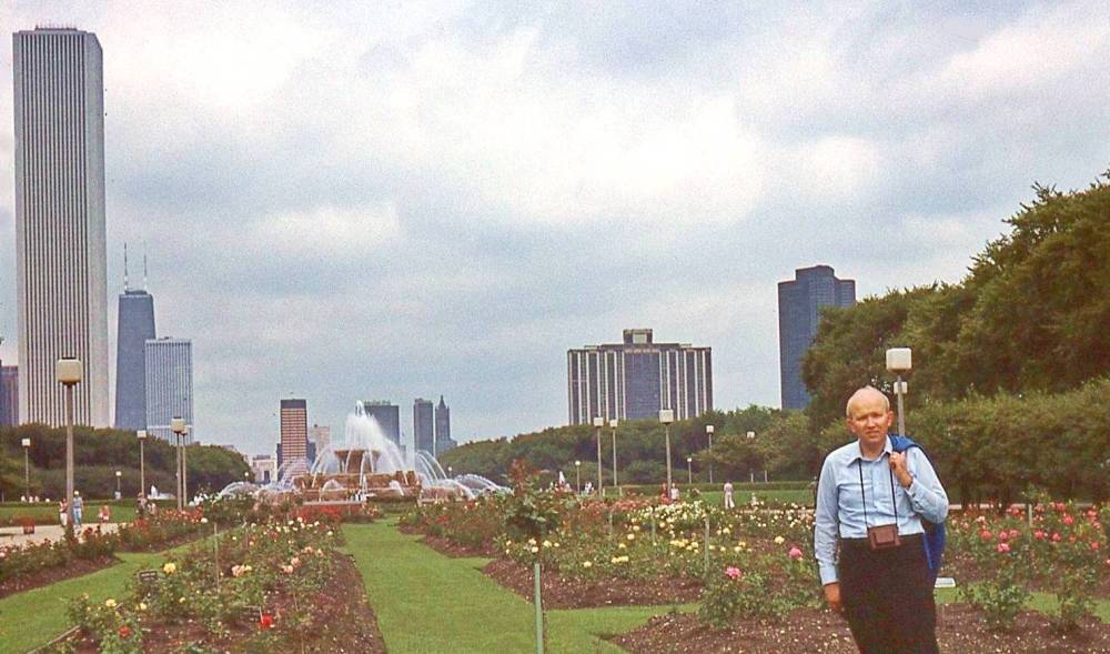 AA PHOTO - CHICAGO - UNKNOWN MAN STANDING IN GRANT PARK ROSE GARDEN - BUCKINGHAM FOUNTAIN IN BACKGROUND - STANDARD OIL BUILDING BACK LEFT - 1977