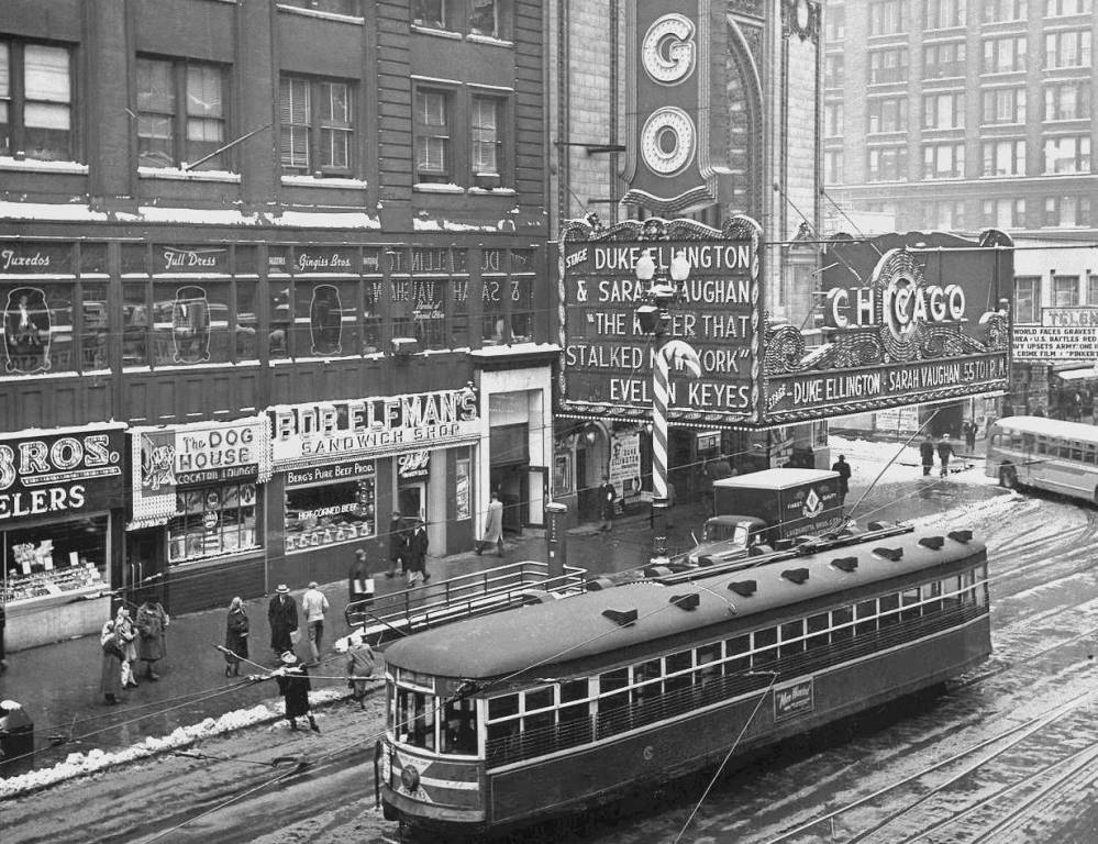 A PHOTO - CHICAGO - STATE STREET - CHRISTMAS SEASON - CHICAGO THEATER AND SURROUNDINGS - BOB ELFMAN SANDWICH SHOP - THE DOG HOUSE - STREETCAR IN FRONT - ELEVATED VIEW - LOOKING SE - 1951- EDITED FROM A HAROLD BEACH IMAGE
