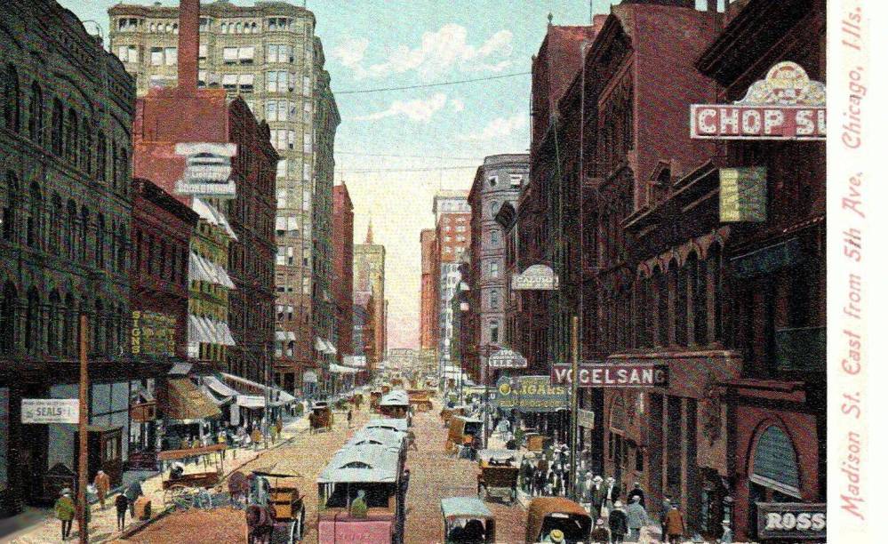 A POSTCARD - CHICAGO - MADISON STREET - E FROM 5TH AVE (NOTE FROM 1879 TO 1912 WELLS STREET WAS CALLED 5TH AVE)- THE STREET ADA - SLIGHTLY ELEVATED VIEW - CABLE CARS - WAGONS - VOGELSANG RESTAURANT - CROWDS - TINTED - c1905